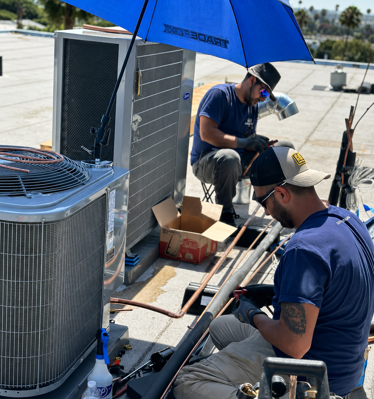 Static Mechanical technicians installing copper refrigerant lines beside rooftop condenser units.