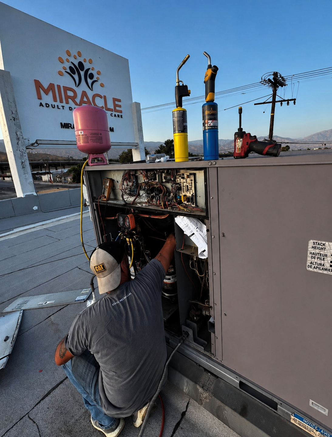 Static Mechanical technician diagnosing an open commercial rooftop HVAC unit.